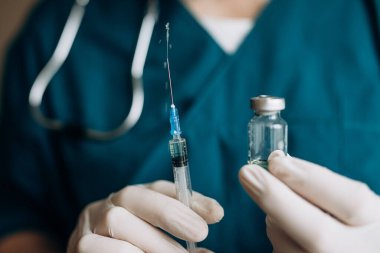 Doktor elinde bir şırınga ve aşı tutuyor. Covid-19 'a karşı aşı. Coronavirus. Grip aşısı.