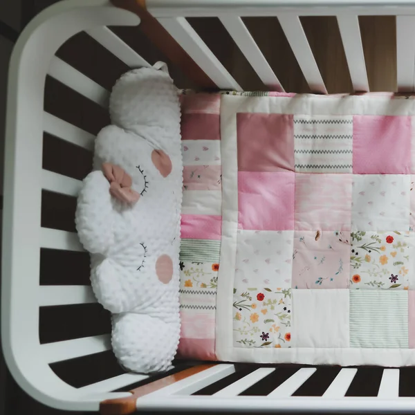 Acogedora cuna con manta patchwork rosa. Ropa de cama y textil para guardería infantil. Foto de cuna de niña rosa y blanca —  Fotos de Stock