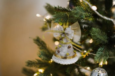 Noel ağacı ve dekorasyon çanı yakın. Mutlu yıllar ve mutlu noeller. Şenlikli bir iç mekan. Seçici odak