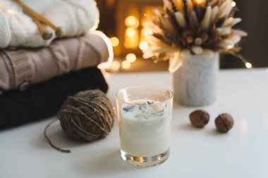 Örülmüş yün kazaklar, iğneler, mumlar arka planda. Hygge rahat bir hayat sürüyor. Kış, Yeni Yıl geçmişi