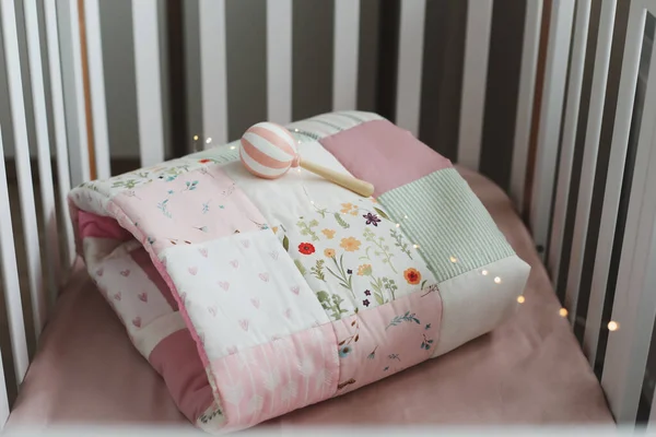 Rosa cálido mosaico manta vista superior. Acogedora cuna de niña con manta. Ropa de cama y textil para guardería infantil —  Fotos de Stock