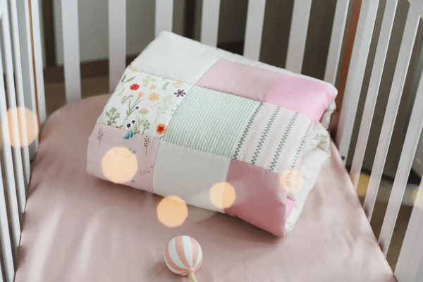 Рожеве тепле клаптикове покриття вид зверху. Затишне дитяче ліжко з ковдрою. Постільна білизна та текстиль для дитячої розплідниці — стокове фото