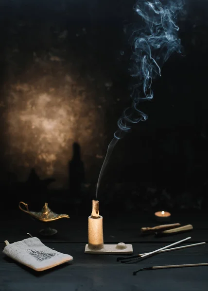 Palo Santo stick with smoke in a candlestick. Meditation, relaxation concept. Palo santo wood, Aromatic sticks on dark background