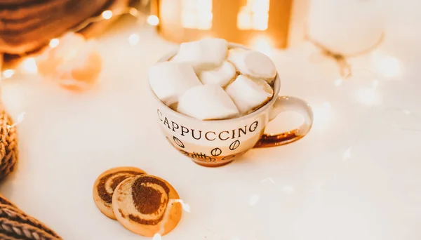 Tazza di caffè con marshmallow e biscotti su sfondo luci bokeh. Natale e Capodanno accogliente nature morte luci e decorazioni — Foto Stock