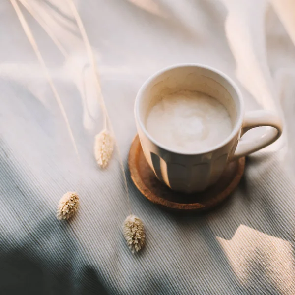 Tasse de café au lait sur carreaux beige. Couché plat, vue sur la nature morte matin petit déjeuner. Confort, confort et concept de chaleur. Photo en couleurs pastel clair — Photo