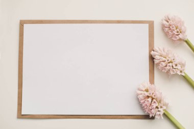 Düğün ya da doğum günü düz kompozisyon pembe çiçekler ve boş kağıt kart, maket, davetiyeler. Düz görünüm, üst görünüm, boşluk kopyala