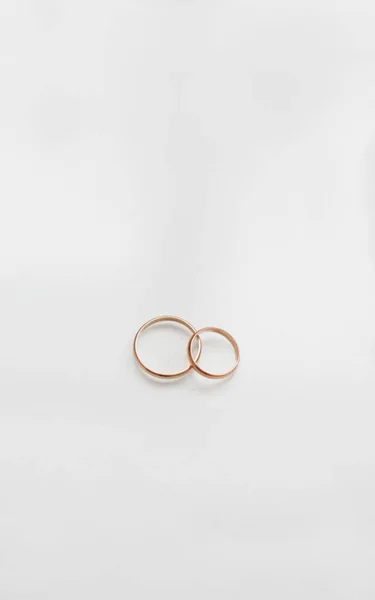 Dos anillos de boda dorados sobre fondo blanco — Foto de Stock