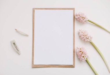Pembe çiçekli maket ve kopyalama alanı olan boş kağıt.. 