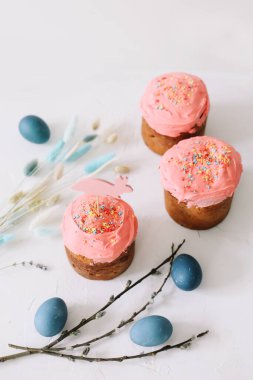 Paskalya pastası, renkli yumurtalar ve açık arkaplanda söğüt dalları.