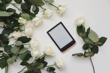 Tabletli çiçek kompozisyonu, beyaz arka planda taze beyaz güller. Flatlay, üst manzara. Boşluk düzenleme şablonunu kopyala.