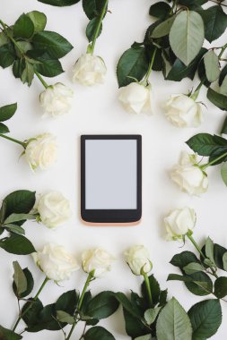 Tabletli çiçek kompozisyonu, beyaz arka planda taze beyaz güller. Flatlay, üst manzara. Boşluk düzenleme şablonunu kopyala.