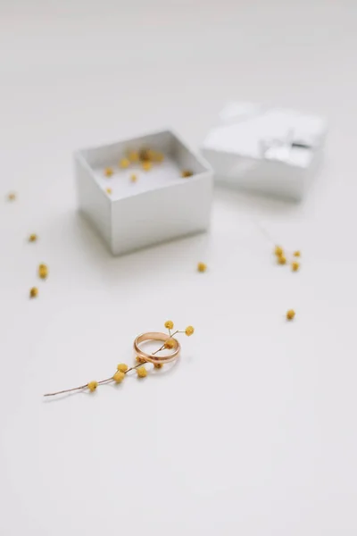 Caja con anillo de compromiso dorado sobre fondo de flores, vista superior. Boda, concepto de propuesta de matrimonio — Foto de Stock