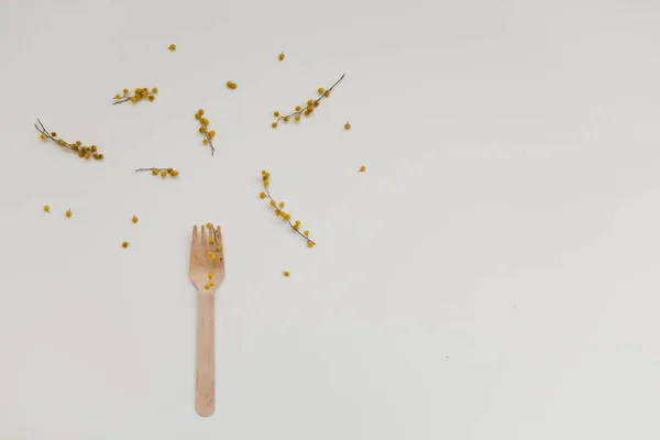 Tenedor de madera, cubiertos de bambú y flores mimosas sobre fondo blanco, cero residuos, sin plástico, concepto ecológico — Foto de Stock