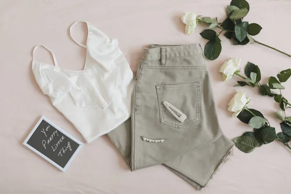 Jeans de mujer, sandalias, lencería y flores vista superior. Traje de primavera verano elegante para mujer. Ropa de moda. Puesta plana. — Foto de Stock