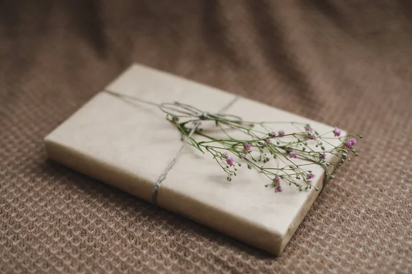 Una caja de regalo en papel artesanal decorado con una flor — Foto de Stock