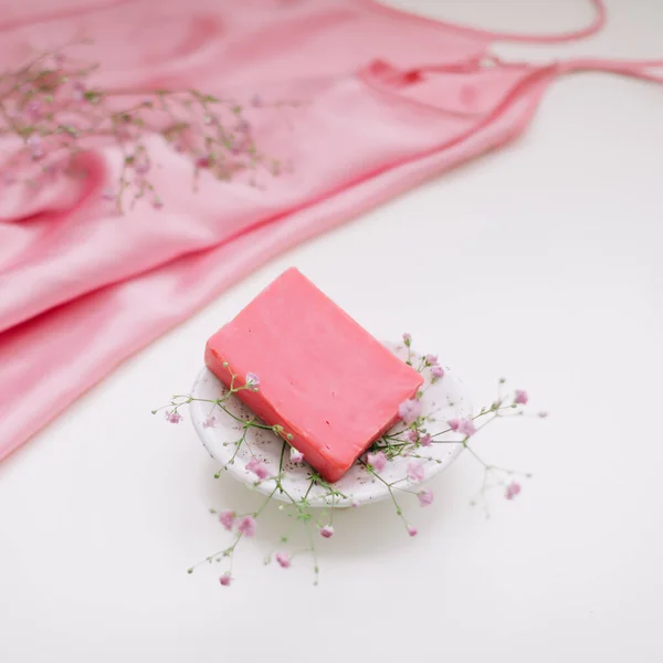 Спа-композиция с розовым мылом бар с керамической мыло блюдо, шелк babric и цветы — стоковое фото