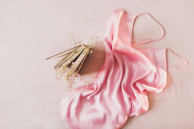 Bir kitap, çiçekler ve ipek kumaşlı romantik bir kompozisyon. Düz yat, üst görünüm, maket yap.