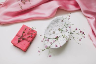 Seramik sabun çanağı, ipek bebek ve çiçeklerle pembe sabun barlı spa kompozisyonu