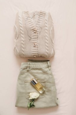 Gündelik kadın kıyafetleri, şık kıyafetler ve bej arka planda aksesuarlar. Düz yatıyordu