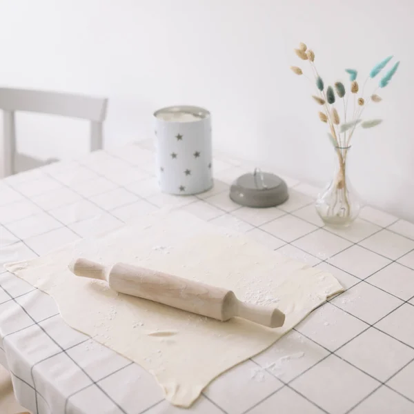 Cottura fatta in casa. mattarello in legno con pasta sul tavolo della cucina — Foto Stock