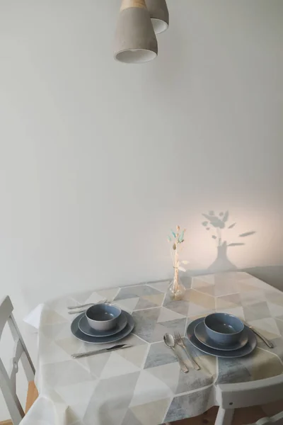 Accogliente cucina moderna con tavolo e sedie serviti. Set di piatti sul tavolo in legno con tovaglia — Foto Stock