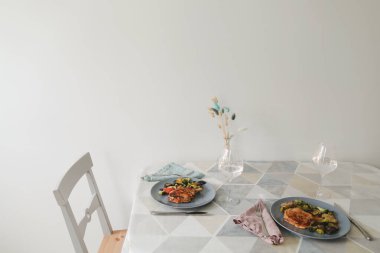 Masa evdeki yemek masasını hazırlıyor. Izgara biftek ve sebze.