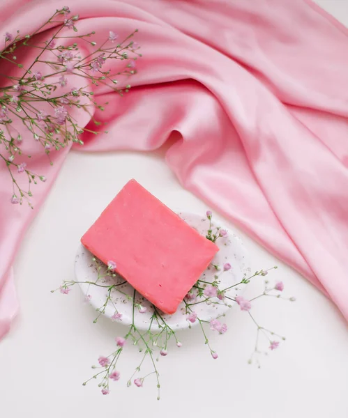 Романтическая композиция с розовым мылом с керамическим блюдом и серебряным платьем. — стоковое фото