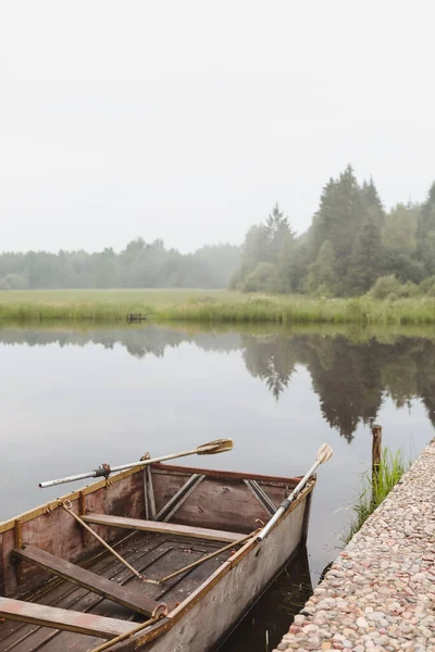 Деревянная лодка у пирса на озере — стоковое фото
