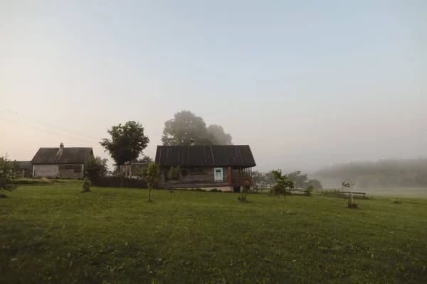 Paysage rustique pittoresque avec maison en bois au lever du soleil — Photo