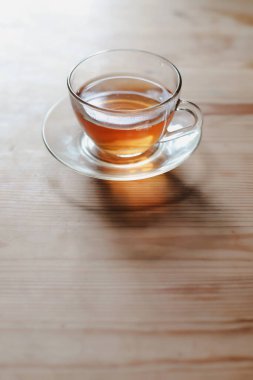 Tahta bir masanın üzerinde bir bardak çay.