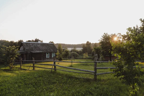 Maison européenne en bois dans une campagne pittoresque au coucher du soleil en été — Photo