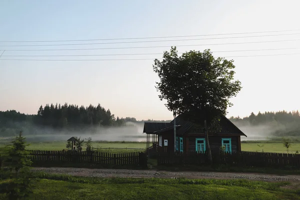 Dřevěný evropský dům v malebné krajině při západu slunce v létě — Stock fotografie