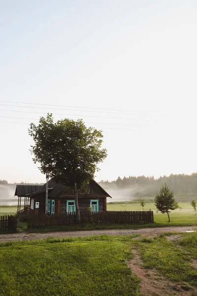 Trä europeiskt hus i en pittoresk landsbygd vid solnedgången på sommaren — Stockfoto
