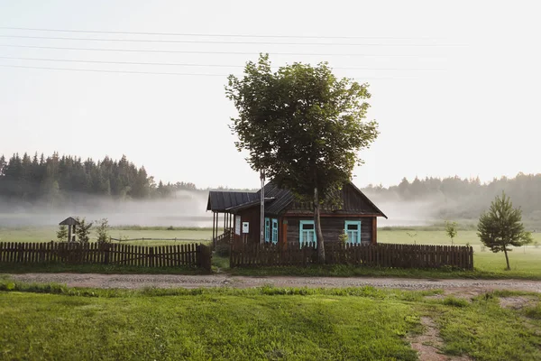 Ξύλινο ευρωπαϊκό σπίτι σε μια γραφική ύπαιθρο το ηλιοβασίλεμα το καλοκαίρι — Φωτογραφία Αρχείου