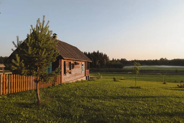 Wooden european house in a picturesque countryside at sunset in summer — Stock Photo, Image