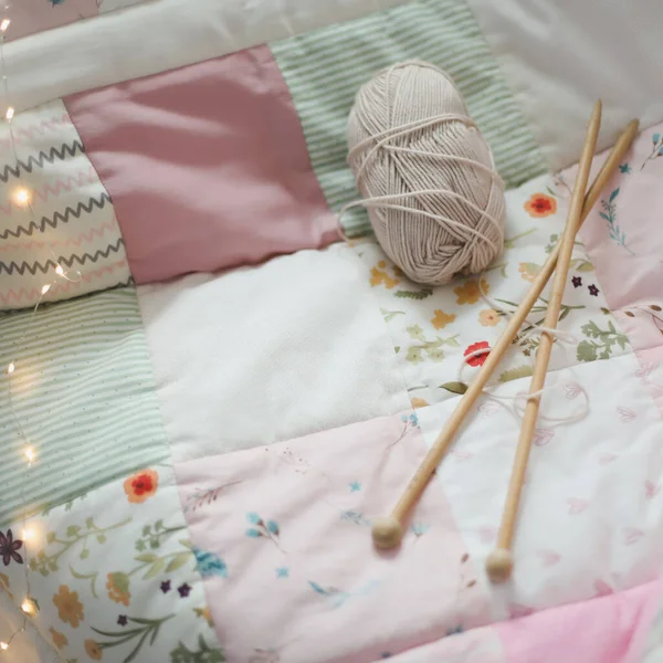 Cozy homely background with wool yarn and knitting needles on an armchair with a blanket. — Stock Photo, Image