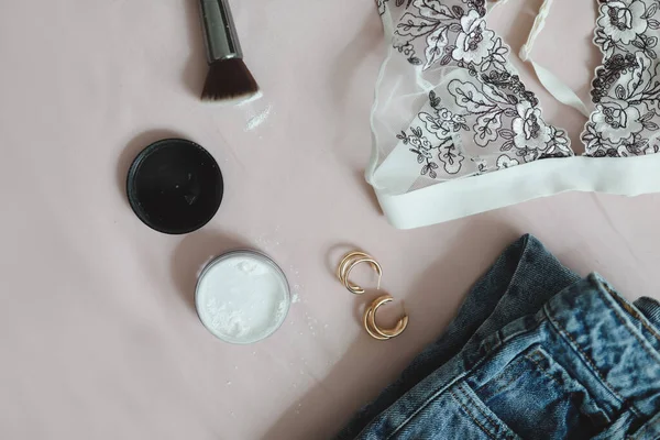 Composição flat lay com roupa interior feminina, sutiã, jeans, cosméticos e acessórios em fundo bege vista superior — Fotografia de Stock