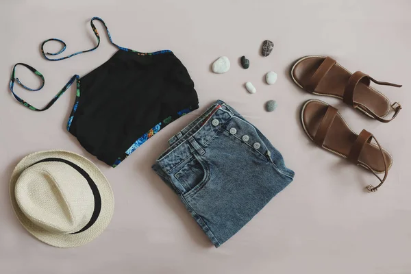 Vlakke lay compositie van zomerkleding met badpak, denim short, strohoed en sandalen. vakantie op zee concept — Stockfoto