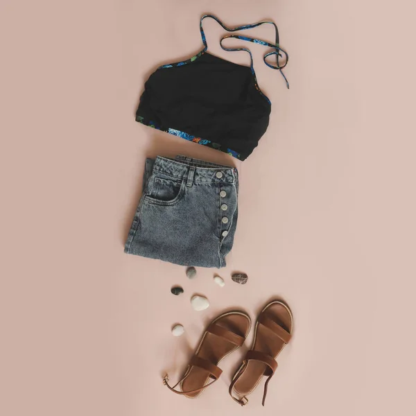 Composizione flat lay con costume da bagno femminile, pantaloncini di jeans e sandali su sfondo beige vista dall'alto — Foto Stock