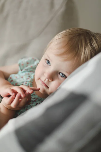 집의 격자무늬 밑에 누워 있는 귀여운 두 살난 여자 아이 — 스톡 사진