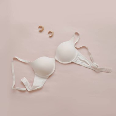 Bej arkaplan takılı beyaz dantel sutyen.