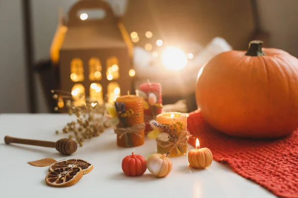 Cozy autumn composition with pumpkin, wax candles, dry leaves by bokeh lights background. Fall, Halloween, Happy Thanksgiving concept — Stock Photo, Image