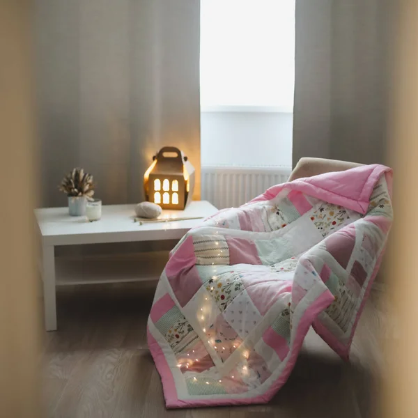 Acogedora habitación con un sillón con una manta, hilo de lana y agujas de punto en una mesa junto a la ventana —  Fotos de Stock