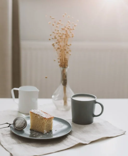 Утренний завтрак с кусочком свежего домашнего торта с чашкой капучино на столе со скатертью. — стоковое фото
