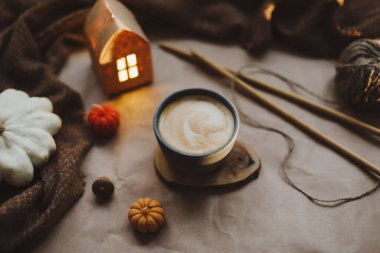 Sonbahar, evin iç kısımlarında bir fincan, mumlar ve ekoseyle sakin bir hayat sunar. Hygge ev dekoru. Cadılar Bayramı ve Şükran Günü konsepti 