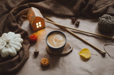 Sonbahar, evin iç kısımlarında bir fincan, mumlar ve ekoseyle sakin bir hayat sunar. Hygge ev dekoru. Cadılar Bayramı ve Şükran Günü konsepti 