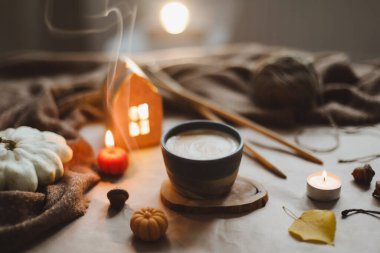 Sonbahar sıcacık ev içleri, bir fincan, mumlar, ekose kumaşlar. Hygge ev dekoru. Cadılar Bayramı ve Şükran Günü konsepti 