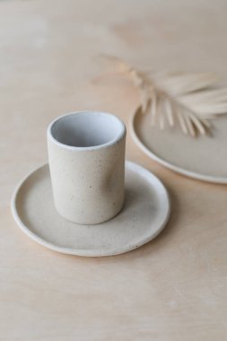 Ahşap masa manzaralı seramik bardak ve tabaklar. Minimalist el yapımı seramik sofra takımı ve çömlek