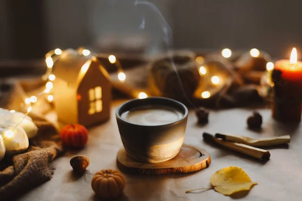 Sonbahar, evin iç kısımlarında bir fincan, mumlar ve ekoseyle sakin bir hayat sunar. Hygge, Cadılar Bayramı ve Şükran Günü konsepti — Stok fotoğraf