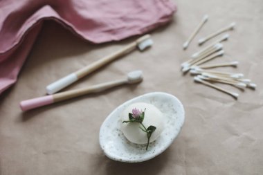 Çevre dostu ürünler. El yapımı doğal sabun, ahşap diş fırçası, pamuk çubuğu ve el işi kağıt arka plan görünümlü saç fırçası.